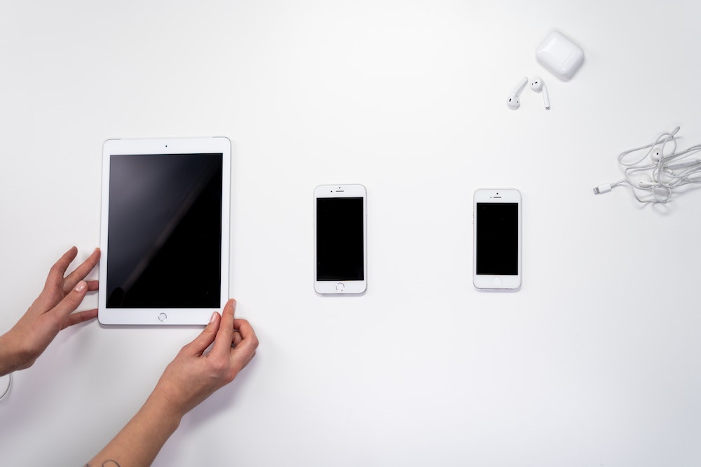 Technogarage - Riparazione iPhone Empoli - foto di iPad, iPhone su tavolo bianco